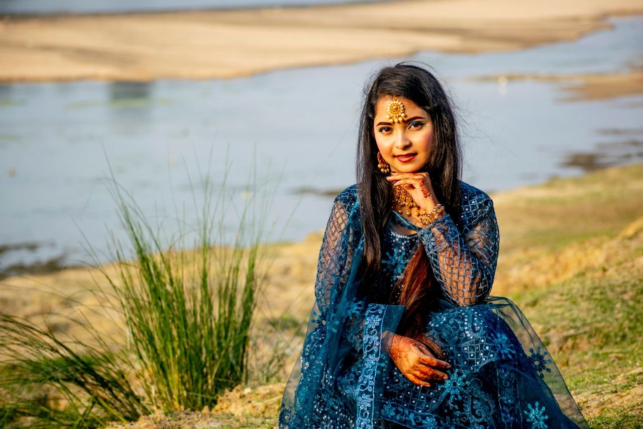 Stunning portrait of a young woman in traditional attire by the riverbank. Perfect for cultural and fashion themes.