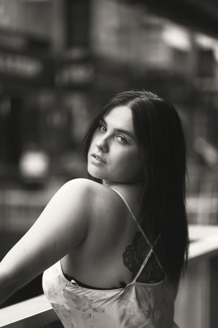 Elegant black and white portrait with a woman glancing over her shoulder, creating intrigue.