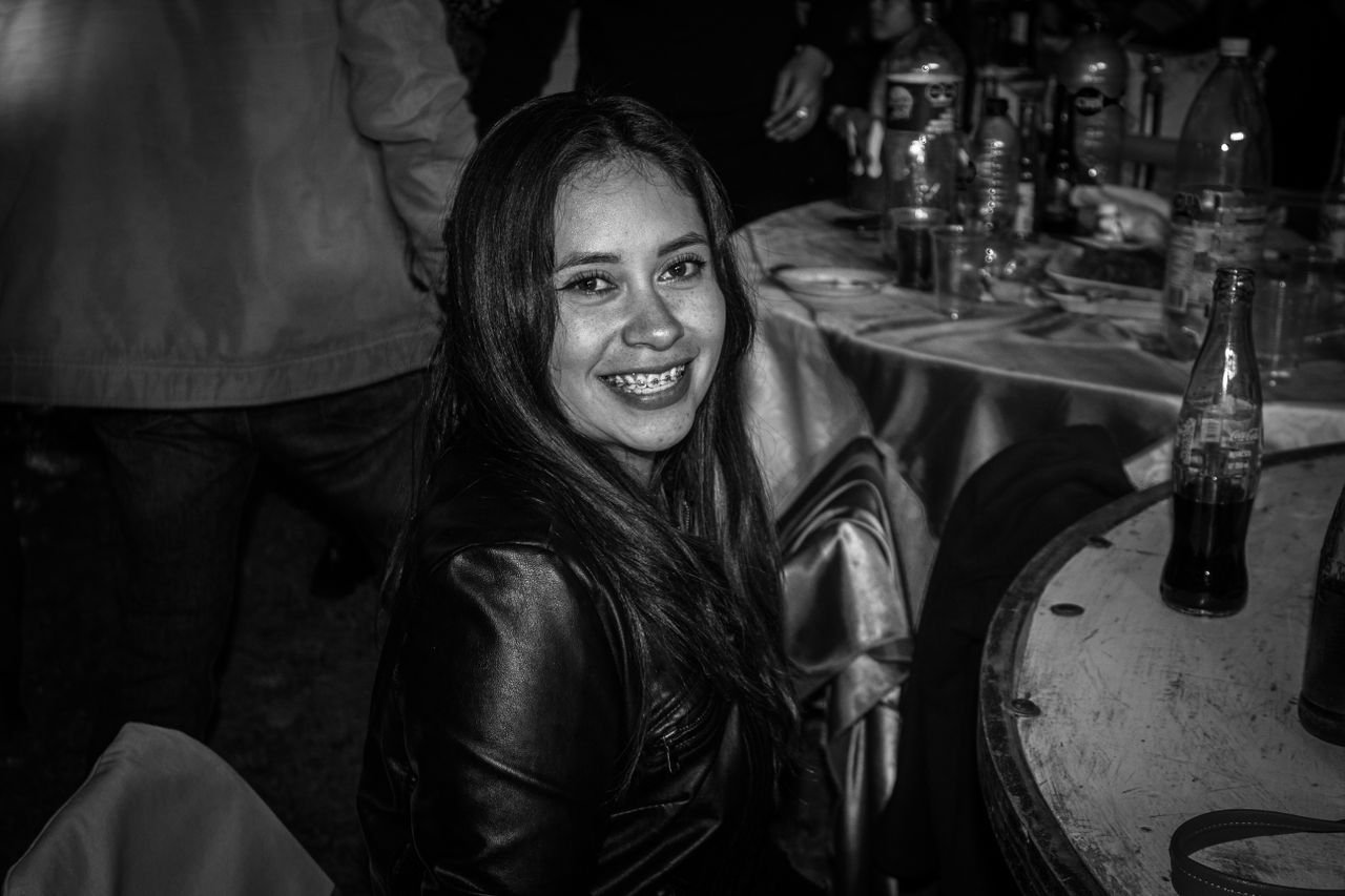 Black and white photo of a woman smiling at a party in Santiago Zautla, Mexico.